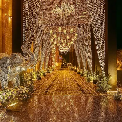 An entrance that promises a night of pure gold. We designed this spectacular golden crystal and chandelier-lined walkway to create a jaw-dropping first impression for a luxury reception.