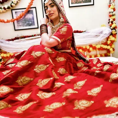 For a royal and traditional pre-wedding shoot, you can rent this beautiful red bridal lehenga. It's perfect for creating a classic look with rich colors and details.