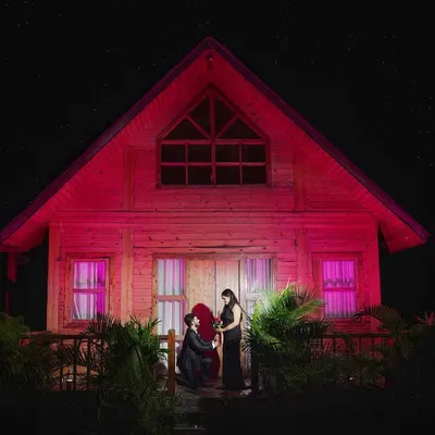 We set up this magical night proposal scene in front of a rustic cabin. The dramatic red lighting and the starry sky create a highly cinematic and unforgettable image, turning a special moment into a work of art.