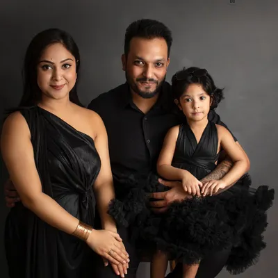 **Timeless Dark:** A classic family portrait in all black against a dark grey backdrop. This style is sophisticated, elegant, and truly timeless.