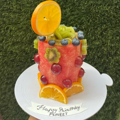 Our literal 'fruit cake' is a fun and unconventional centerpiece for any summer party. This one is carved from a watermelon and decorated with fresh kiwi, grapes, and oranges.