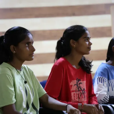 Young athletes at the Anantapur Sports Academy listen intently during a session for the Female Athlete Leadership Program. This image captures the focus and engagement as they absorb lessons on leadership and personal growth.