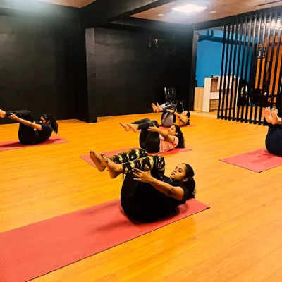 A shot from our power yoga class, with members engaging their core in a boat pose variation. These exercises are key for building a strong foundation.