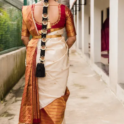 This is the back view of a classic South Indian bridal look, showcasing the perfectly draped Kanjeevaram saree and a traditional 'poola jada' (floral braid) with hair ornaments.