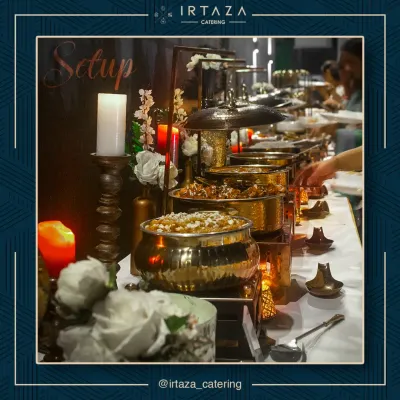 A glimpse of a full buffet setup, where golden serving dishes and warm candlelight create an inviting and luxurious atmosphere for your guests.