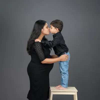 A mother's kiss for her son, while waiting for the new arrival. Maternity sessions with older siblings are so special, capturing the moment before the family grows.