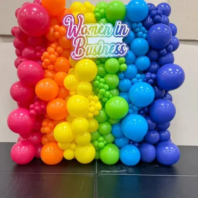 This custom 'Women in Business' backdrop combines a full spectrum of colorful balloons with a bright neon sign. It’s a great example of how we create visually impactful and on-brand photo walls.