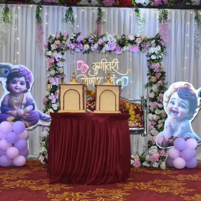 A complete Dohale Jevan stage setup featuring a floral arch, a 'Kunitari Yenar Ga' neon sign, and cute Krishna cutouts.