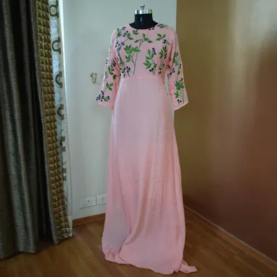 This soft pink gown is all about subtle elegance. The delicate green floral embroidery on the bodice and sleeves adds a touch of nature-inspired beauty, making it perfect for a daytime event.