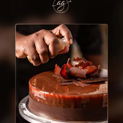 Every celebration deserves a stunning cake. Here, I am adding the final touches to a rich chocolate cake, complete with a delicate, handcrafted chocolate flower. I can customize cakes for any occasion.