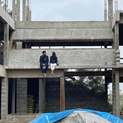 A moment of pause on site, sitting on a concrete beam of a house under construction. This is where the vision starts to take shape, and we can truly feel the scale and form of the future home.