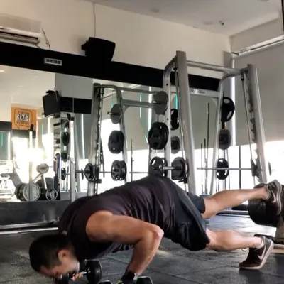 This client demonstrates a challenging dumbbell push-up, which enhances chest strength and core stability. His focus and determination during brutal workouts are always impressive.