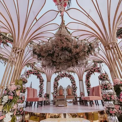A full view of Yasha and Rahil's stunning seaside mandap. The open, airy structure allowed the natural beauty of the ocean to become part of the decor, while the blush florals and intricate design added a layer of romance and elegance.
