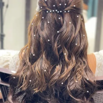 A close up of the beautiful pearl-adorned hairstyle for a Catholic bride. The pearls look like delicate dewdrops in her hair.