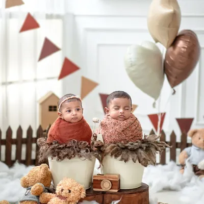 Two little bundles of joy, each in their own cozy bucket. This setup allows each twin to have their own space while still being part of a beautiful, coordinated scene.