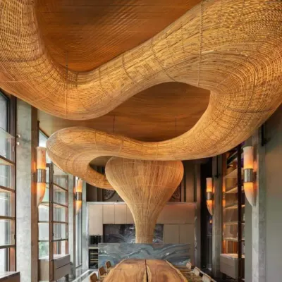 This large-scale, custom-woven rattan light installation is a centerpiece in a luxury space, demonstrating our capability to create breathtaking, architectural statements. We designed this piece to flow organically within the high-ceilinged room, creating a warm and dramatic focal point over the dining area.