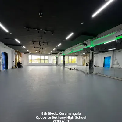 An expansive view of the empty Koramangala studio. This shot captures the sheer size of the 2200 sq.ft space, the bright, clean flooring, and the wall-to-wall mirrors, ready for you to fill with your creativity.