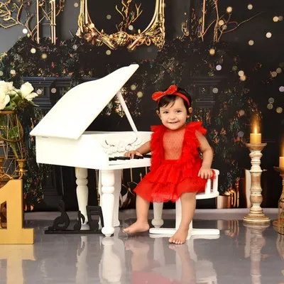 For this little musician's first birthday, we created a glamorous piano theme. I love capturing these moments of curiosity and joy as she discovers the world around her in this elegant setting.