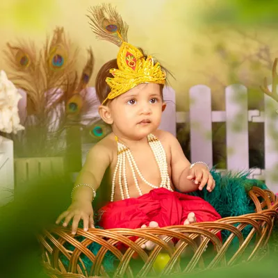 A close-up of our little Krishna, showcasing the detailed costume with a pearl necklace and peacock feather mukut (crown). These themed shoots are designed to be both beautiful and culturally significant.