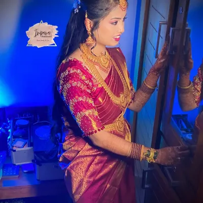 A radiant bride ready for her reception. This HD bridal look features a glossy finish and soft glam eye makeup, perfectly complementing her embroidered saree and making her glow.