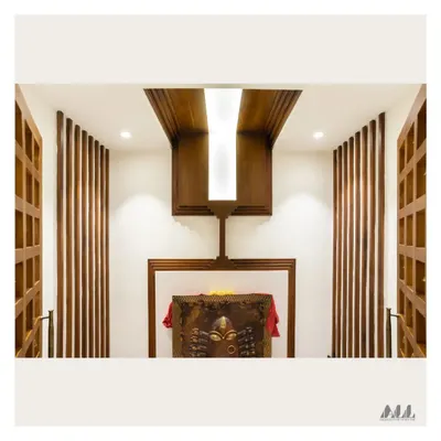 The interior of the Pooja room before placing the idols. The design features a dramatic wooden ceiling element with a central light, flanked by vertical wooden slats that add texture and warmth.