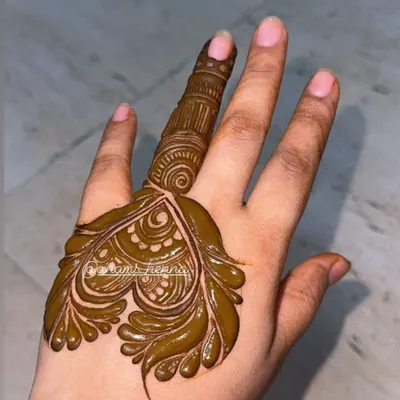 A simple and elegant leaf-motif design on the back of the hand. This is a perfect example of a quick yet beautiful design for a party or festival.