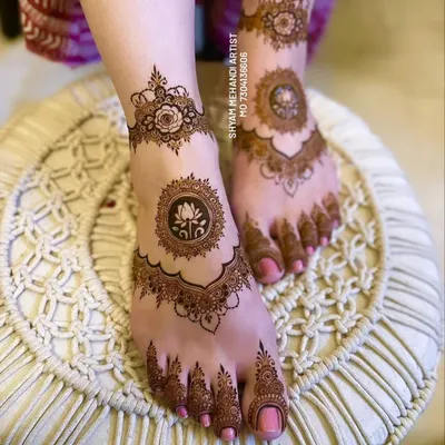 An elegant foot mehandi design featuring a central lotus mandala. The clean lines and symmetrical patterns create a sophisticated look.