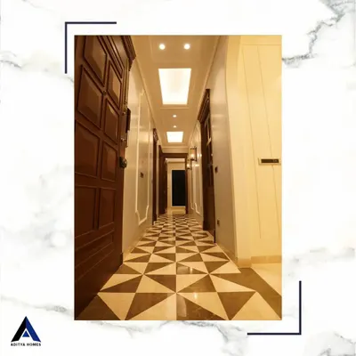 This hallway is a masterpiece of material and pattern. The floor is laid with three different types of Italian marble in a complex geometric pattern, complemented by solid wood doors and detailed wall paneling.