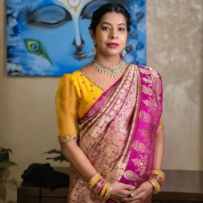 A beautiful mother-to-be in a yellow and pink Kanchipuram saree. Her custom yellow blouse with puffed sleeves was designed for both comfort and style during her baby shower.