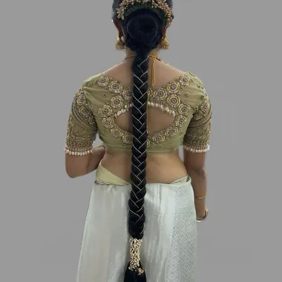A stunningly intricate bridal braid, woven with pearls for a modern yet traditional muhurtham hairstyle. This look is all about detailed craftsmanship.