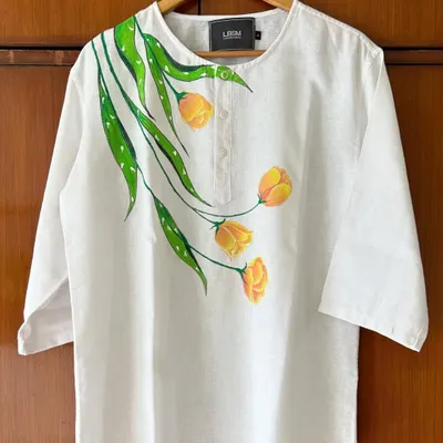 A closer look at a custom hand-painted linen kurta. The yellow tulip design flows organically from the neckline, making the garment a unique piece of floral art you can wear.