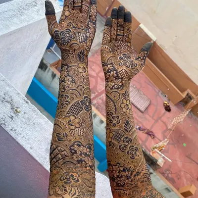 Full-arm bridal henna for Salma, showcasing a blend of Pakistani and floral styles. The design features detailed flowers, paisleys, and geometric fills for a breathtaking result.