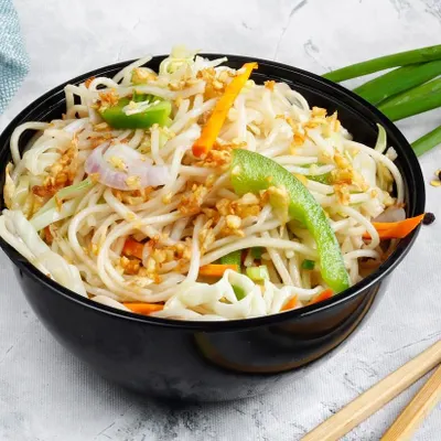 A bowl of our simple yet delicious Garlic Noodles. The noodles are tossed with fried garlic, spring onions, and sliced peppers for a light and aromatic flavour.