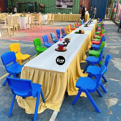 A long table set up just for the kids, with a rainbow of colorful chairs. This ensures the little ones have their own dedicated space to eat and play.