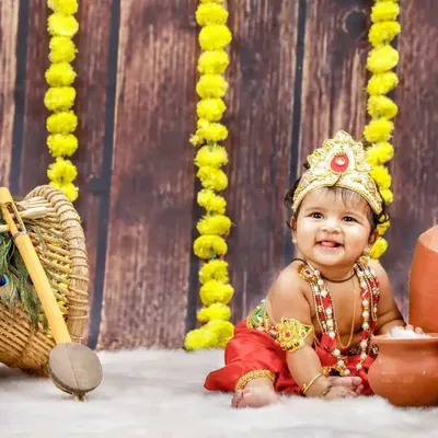 Celebrating Krishna Jayanthi with our adorable little Krishna! This setup features clay pots, marigold flowers, and a beautiful smile that could steal anyone's heart.