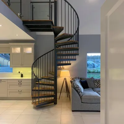 This spiral staircase fits neatly into the corner of a living space, providing access to a mezzanine without taking up a large footprint.