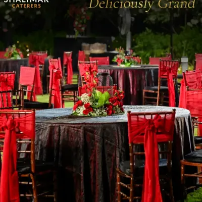 We transform outdoor spaces into grand dining venues. This setup features our classic red and black theme, with elegant chair dressings and floral centerpieces that create a dramatic and celebratory mood.