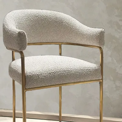 Commissioned for a client, this armchair and matching footrest feature soft bouclé upholstery on a slender, gold-finished frame. The design balances tactile comfort with a minimal silhouette, creating a piece of functional, understated luxury.