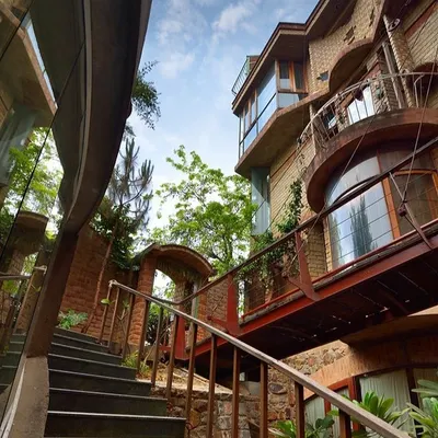 This home is a living example of bioclimatic architecture, designed to work in harmony with nature. The structure is built from Compressed Stabilised Earth Blocks (CSEB) made from the very soil of the site, minimizing our carbon footprint. This low-angle view from the basement level shows how every part of the home, including the stairways and bridges, is designed for natural light and ventilation.
