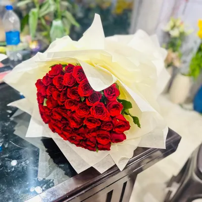 A large, classic bouquet of fresh red roses, wrapped in simple cream paper to let the flowers stand out. This is a timeless gift for expressing love and appreciation.