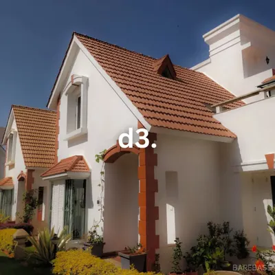The facade of a classic villa we designed, featuring clean white walls, traditional tiled roofing, and subtle brick accents. This project shows our ability to execute timeless architectural styles.