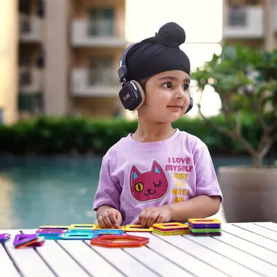 Capturing a moment of focused play. This lifestyle shot for a kids' wear brand feels authentic and highlights the clothing in a natural setting.
