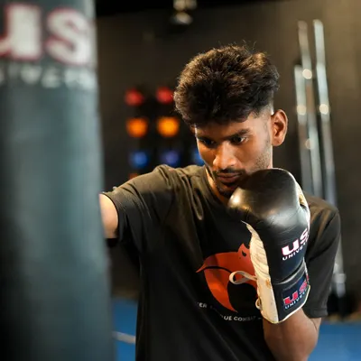 A fighter works on his punches with the heavy bag. This drill is fundamental for improving punching power, technique, and cardiovascular endurance, all while relieving stress.