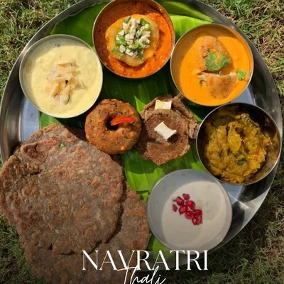 Our signature Navratri Thali, beautifully plated on a banana leaf and served outdoors. It features a complete meal with kuttu ki puri, sabzis, raita, and sweets, all prepared according to vrat guidelines.