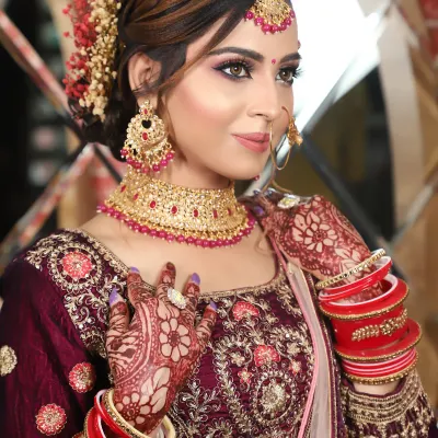 This bride's look is all about royal elegance in a deep wine-colored lehenga. I used shades of purple and pink on her eyes and paired it with a matching choker set for a cohesive, regal look.