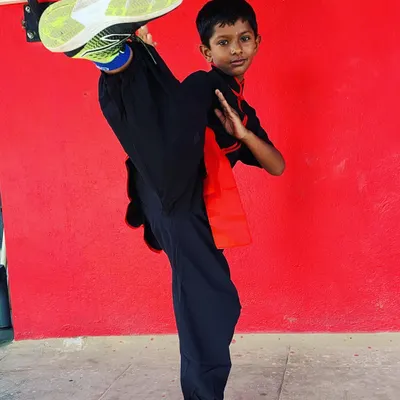 A young student shows excellent form and flexibility with a high kick. Our youth martial arts program builds a strong physical foundation and mental discipline.