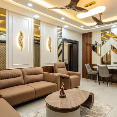 An integrated living and dining space in Mahad, designed for a cohesive look. The design features wood paneling, elegant wall sconces, and a comfortable recliner sofa, all tied together with warm ambient lighting to create a sophisticated and harmonious environment.