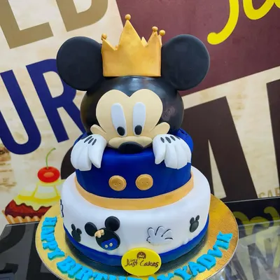 A royal Mickey Mouse theme for a special birthday. This 4kg, two-tiered cake features a large, sculpted Mickey head with a golden crown, combining a classic character with a touch of regal flair.