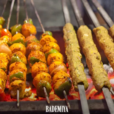 Kebabs sizzling over hot coals at our Colaba stall. This is the sight and smell that has been drawing crowds for decades, especially for those midnight cravings. This picture shows our Paneer Tikka and Veg Seekh Kebabs grilling alongside the non veg classics.