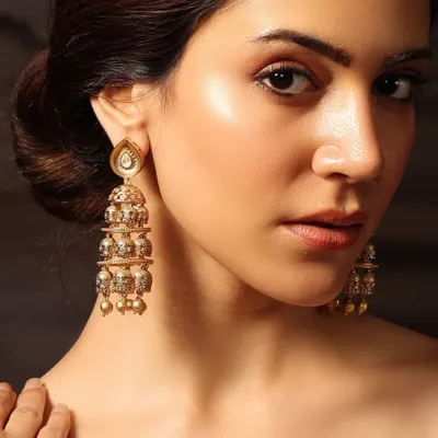 A close-up of our tiered golden jhumkas, worn by Pashmina Roshan, featuring delicate craftsmanship perfect for any celebration.